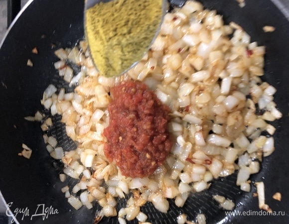 В зажарку добавляем 2 столовые ложки томатной пасты, 1 неполную столовую ложку приправы хмели-сунели, нарезаный помидор, заливаем все бульоном.