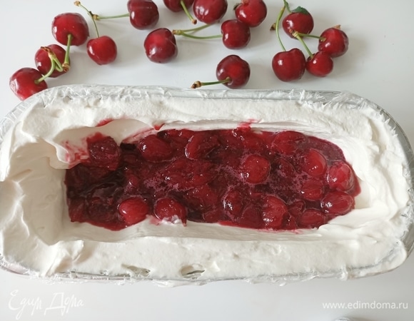 Форму застелить пищевой пленкой. Выложить половину крема. В середине сделать небольшое углубление. Выложить ягоды, накрыть кремом.