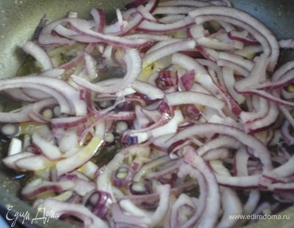 Лук очистить, нарезать тонкими полукольцами и обжарить в оливковом масле до мягкости. Дать остыть.