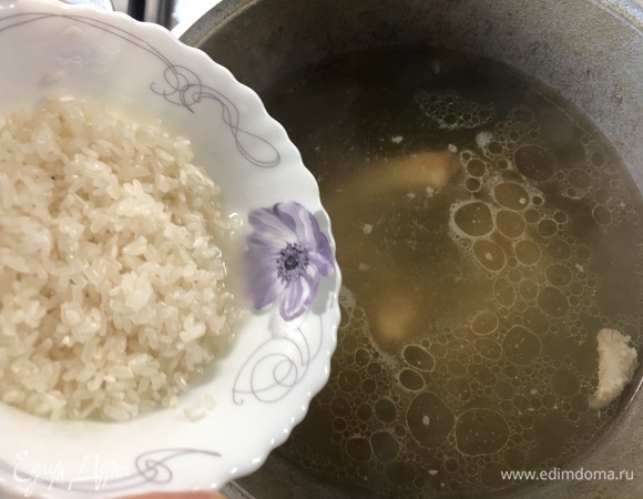 Готовый бульон процеживаем, оставляя в нем мясо, добавляем 5 столовых ложек риса ТМ «Националь», предварительно промыв его.