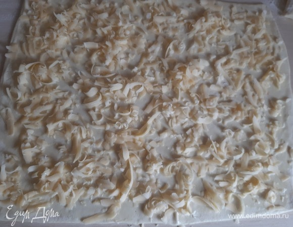 Посыпаем сыром тесто.