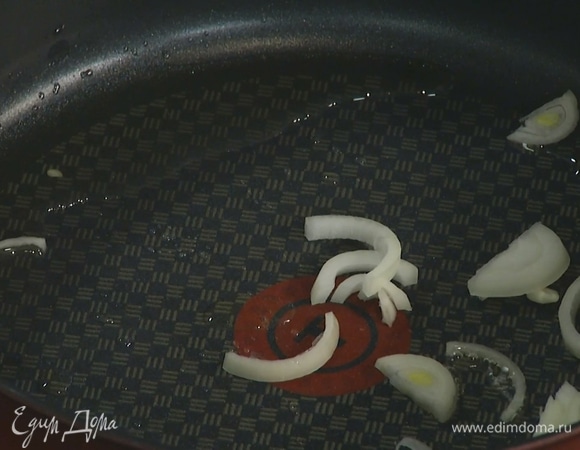 Разогреть в глубокой сковороде оливковое масло и слегка обжарить лук.