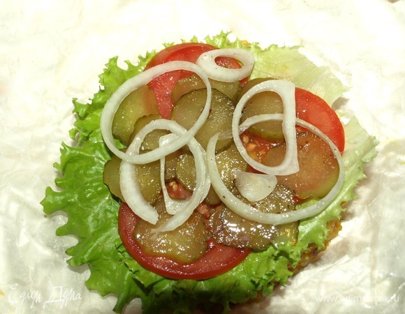 Можно собирать пловбургер. На пловбулочку выкладываем ломтик сыра, листья салата, помидоры, огурцы, лук и немного соуса.