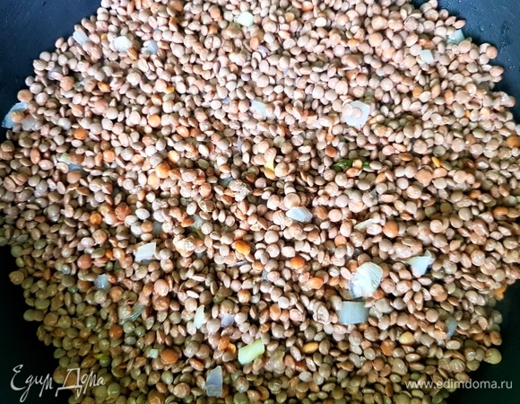 Чечевицу ТМ «Националь» промыть и слить лишнюю жидкость. Выложить к луку, обжарить пару минут, влить стакан воды, посолить и поперчить. Готовить под закрытой крышкой на среднем огне 15 минут.