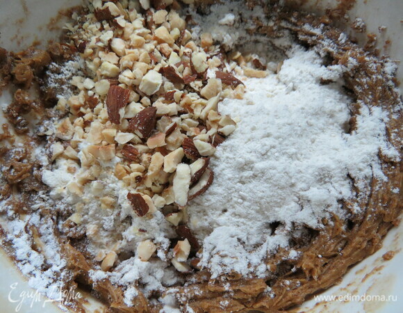 Добавить просеянную муку, разрыхлитель и орехи. Быстро замесить тесто.