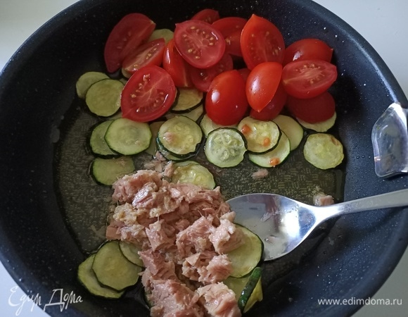 Затем добавить помидоры и тунец. Достать чеснок, он больше не понадобится. Обжарить овощи еще пару минут.