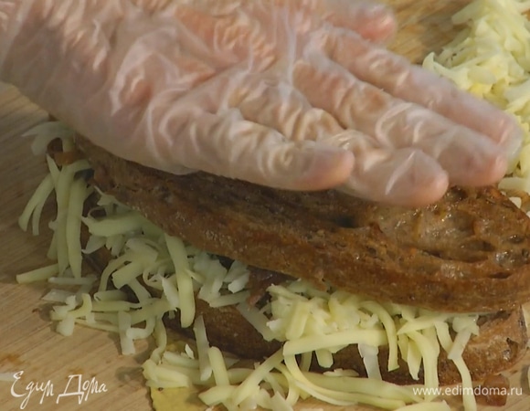 Смазать поджаренный хлеб горчицей, сверху разложить лук, затем два куска посыпать натертым сыром и накрыть хлебом без сыра.