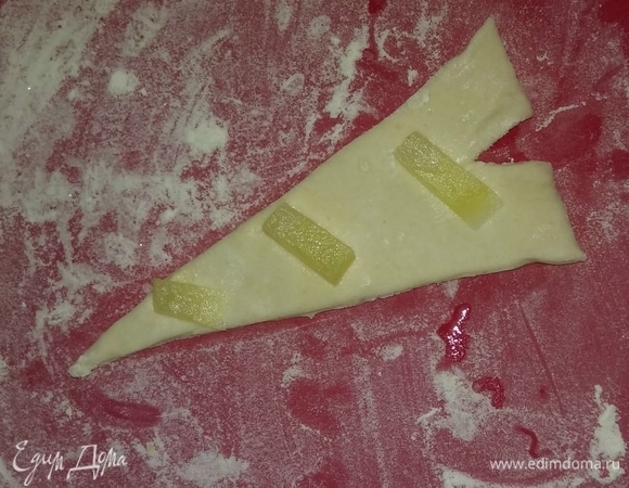 Затем на каждый треугольник, получившийся из одной половины теста, нужно выложить кусочки ананаса.