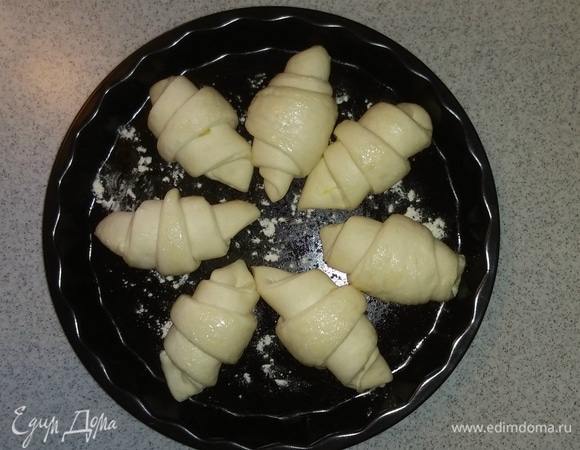 Смазать противень маслом и посыпать мукой. Выложить заготовки на расстоянии друг от друга. Затянуть противень пищевой пленкой и поставить в теплое место на 1,5–2 часа (если ставить противень с заготовками в духовку для расслоения теста, то пленкой затягивать не нужно). Спустя указаное время объем заготовок увеличиться. Затем нужно разогреть духовку до 180°C и поставить в нее противень на 20 минут до образования румяной корочки (время зависит от вашей духовки). Приятного аппетита!