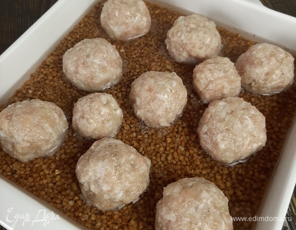 В фарш добавляем измельченный репчатый лук, соль и перец. Формируем шарики и выкладываем на гречку. Убираем в прогретую до 180°C духовку примерно на 20–25 минут.