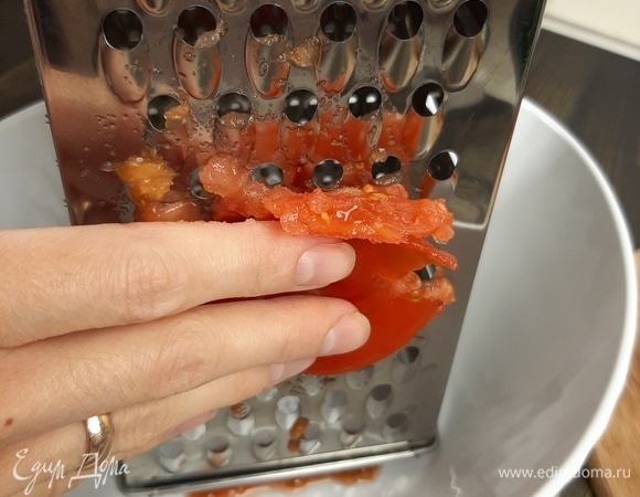 Помидоры разрезаем пополам и натираем на крупной терке со стороны разреза, мякоти. Так кожица у вас останется в руке.