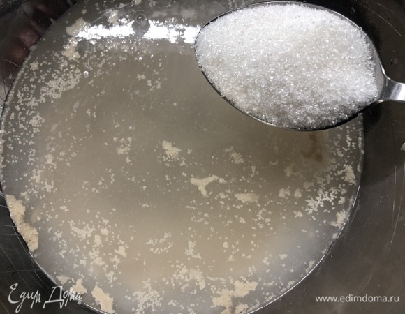 Тесто готовится в два этапа. В первую емкость заливаем теплую воду, всыпаем дрожжи, сахар, накрываем полотенцем. Ждем (у меня это заняло час).