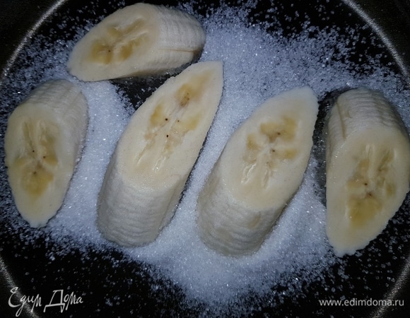 Бананы нам понадобятся с зеленцой. В сковороду насыпать сахар, выложить крупно нарезанные бананы, слегка придавить их и жарить на медленном огне с двух сторон до золотистой корочки.