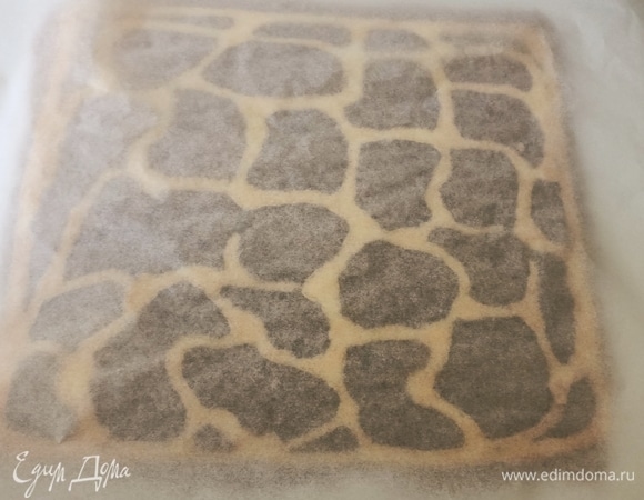 Готовый бисквит положить на пергаментную бумагу пятнами вверх, аккуратно снять бумагу, положить новую и перевернуть бисквит уже темной стороной вверх.