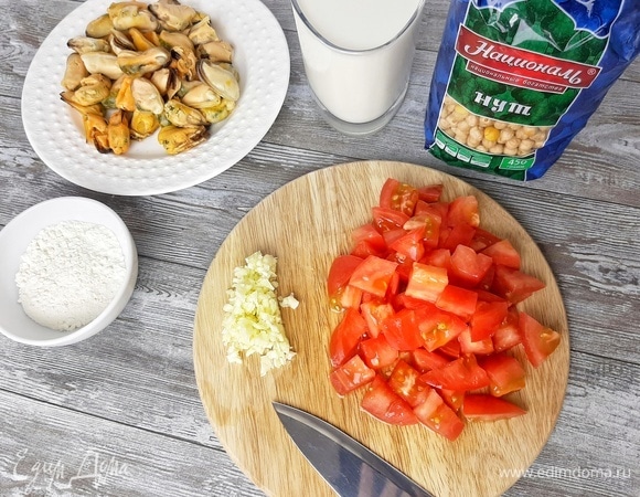 Зубчики чеснока раздавливаем плоской стороной ножа и измельчаем. Помидор нарезаем крупным кубиком.