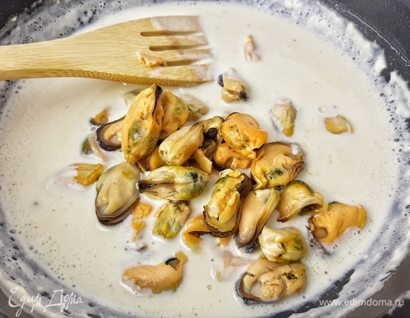 В соус отправляем чеснок, мидии и мелко порубленную петрушку. Готовим на среднем огне 5 минут. Солим по вкусу.
