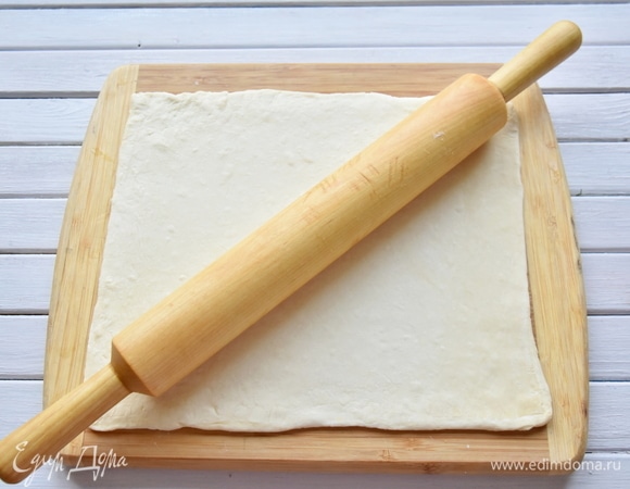 Слоеное дрожжевое тесто разморозить и раскатать в одном направлении в прямоугольник толщиной не менее 0,3 мм.