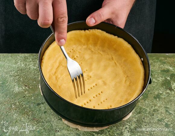 Круглую форму смажьте растительным маслом. Выложите большую часть теста в форму, сформировав бортики. Наколите тесто вилкой в разных местах. Накройте пленкой и поставьте в холодильник на 30 минут. Меньшую часть теста уберите в морозильник.