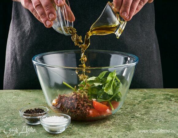 В миску выложите киноа, перец, шпинат, черри. Добавьте чеснок. Посолите, поперчите. Добавьте подсушенные на сковороде тыквенные семечки и заправьте салат маслом.