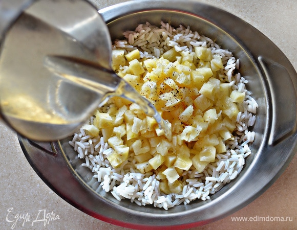 В миску с отварным рисом добавьте нарезанные ананасы, посолите, приправьте перцем и перемешайте.