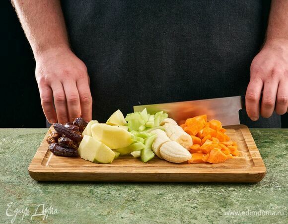 Морковь и яблоки помойте, снимите кожуру. Банан очистите. Нарежьте все на небольшие дольки. Стебли сельдерея помойте и тоже нарежьте небольшими дольками. Из фиников удалите косточки.