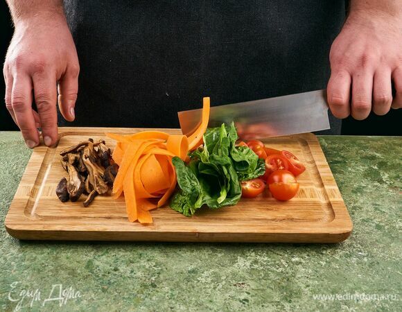 Нарежьте черри пополам, морковь нарежьте на овощечистке, шиитаке нарежьте полосками, шпинат крупно порубите.