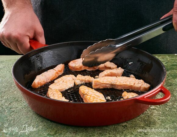 Лосося нарежьте полосками. Разогрейте сковороду с оливковым маслом и выложите рыбу.