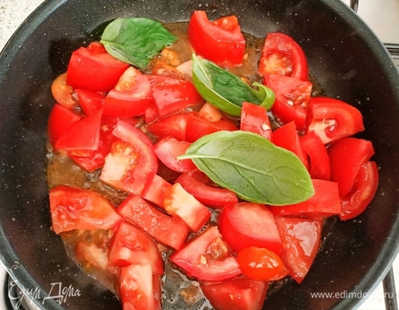 Добавить помидоры и листья базилика. Тушить 3–4 минуты на слабом огне.