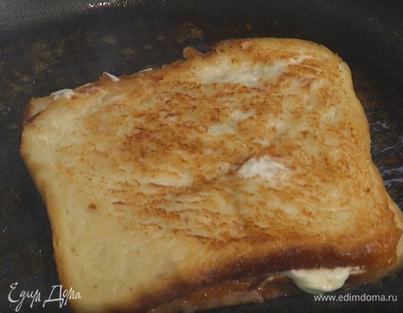 Разогреть в сковороде сливочное масло и слегка обжарить тост с двух сторон, перед подачей разрезать пополам. 