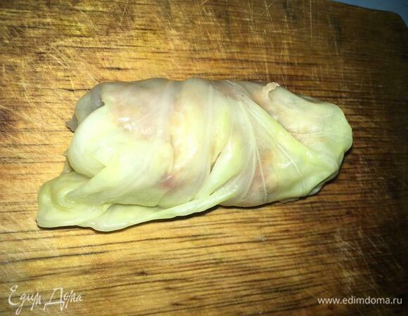 Начинаем заворачивать начинку: после первого оборота складываем края капустного листа и продолжаем сворачивать. В итоге должен получиться рулетик.