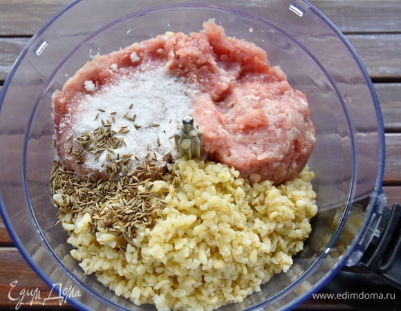 Соединить вместе полуготовую крупу, 400 г фарша, соль и специи. Измельчить все в кухонном комбайне в вязкую, липкую, пластичную массу.
