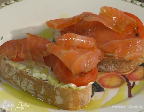 Намазать подсушенный хлеб заправленным сливочным сыром, сверху разложить кусочки помидора и ломтики лосося, полить оставшимся оливковым маслом.
