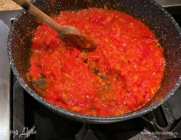Приготовить соус: в тяжелой сковороде разогреть оливковое масло Extra Virgin, слегка обжарить лук и 2/3 измельченного чеснока, всыпать сельдерей и обжарить все вместе, затем добавить томатную пасту, соль, черный перец и чили, перемешать, выложить в сковороду помидоры в собственном соку, еще раз перемешать и томить до готовности.