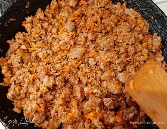 Приготовим мясной соус. Лук нарезать мелкими кубиками, морковь потереть на терке. Обжарить лук и морковь вместе с фаршем до готовности. Добавить приправу для болоньезе, залить водой, перемешать и потушить минут 15. Сметану смешать с водой, посолить.