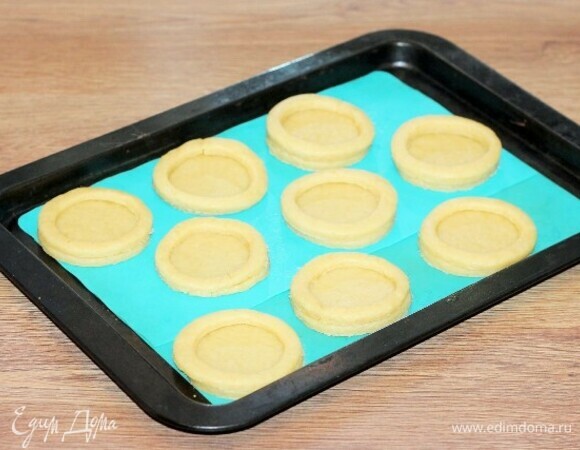 На кружочки теста кладем вырезанные кольца и смазываем их взбитым яйцом. Получились гнездышки.