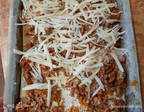 Собираем лазанью. На дно формы выложить листы, сверху — мясной соус, сверху — сметанный соус, немного посыпать сыром. Повторить слои несколько раз. Сверху выложить листы лазаньи, залить сметанным соусом и посыпать сыром.