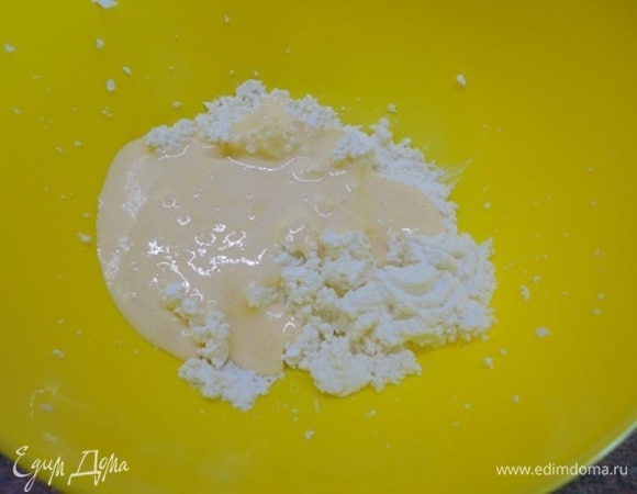 Творог протрите через сито или пробейте погружным блендером до однородной консистенции. Желтки отделите от белков, взбейте с сахаром добела и вместе с цедрой добавьте к творогу. Хорошо перемешайте.