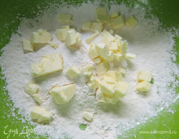 Готовим тесто. В миску просеиваем муку, добавляем соль и сахар. Сюда же рубим кубиками холодное сливочное масло и быстро перетираем его с мукой.