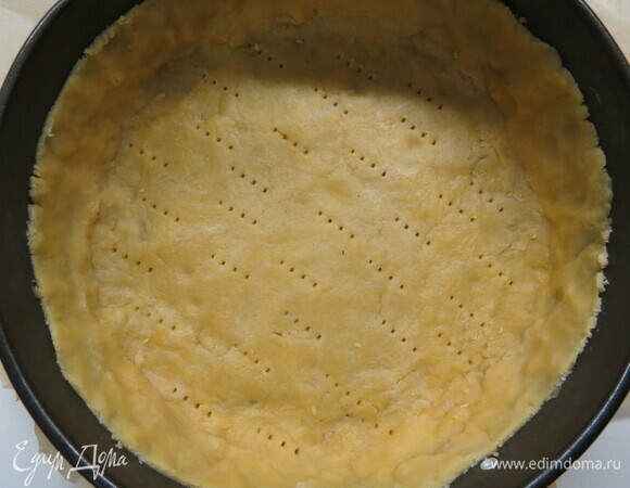 Охлажденное тесто тонко раскатываем. Удобно это делать между 2 листами пергамента. Раскатанное тесто переносим в форму, смазанную сливочным маслом и посыпанную мукой, распределяем тесто по форме. Накалываем тесто вилкой, сверху кладем пергамент и выкладываем груз (горох, фасоль). Я пекла без груза. Отправляем выпекаться в разогретую до 180°C духовку на 30 минут.