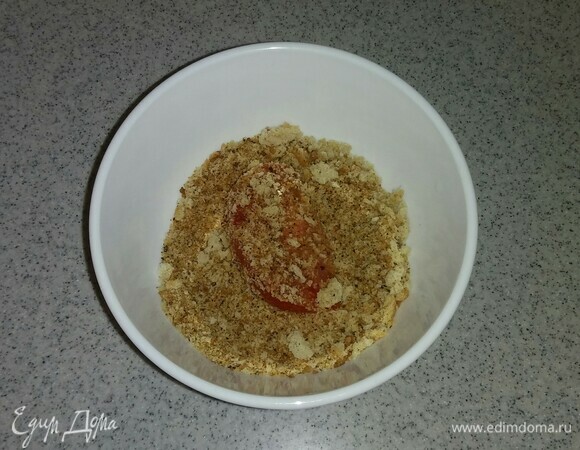 Затем обвалять каждую дольку помидора в сухарях.