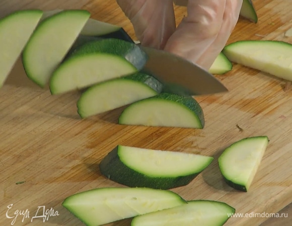 Спаржу нарезать небольшими кусочками, цукини — дольками, добавить все в сковороду и перемешать.