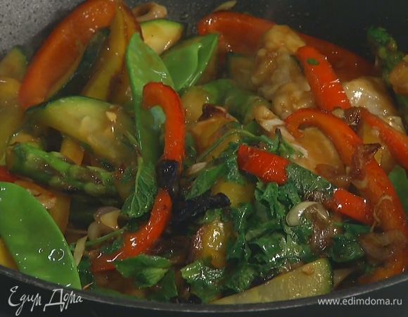 Филе трески разрезать на тонкие полоски, обвалять в муке, выложить к овощам и слегка обжарить, затем влить соевый соус, добавить стручки горошка, листья кинзы и мяты и жарить до готовности.   