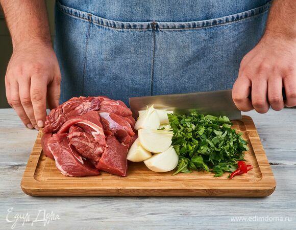 Говядину и лук крупно нарежьте. Базилик и петрушку порубите, перец чили разрежьте и очистите от семян.