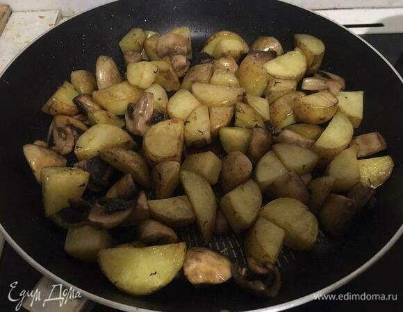Жарим картофель и грибы до появления золотистой корочки, уменьшаем огонь до среднего.