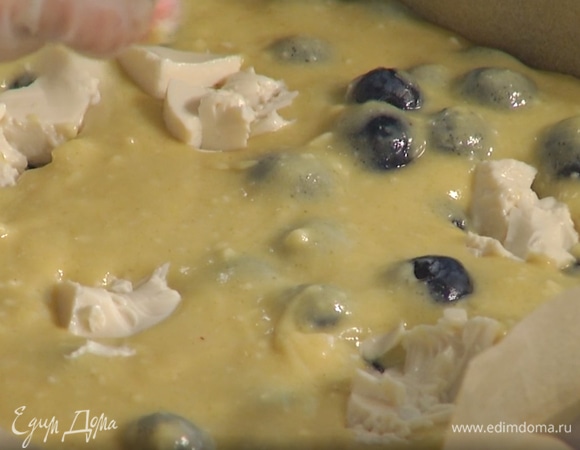 Форму застелить бумагой для выпекания, влить тесто и равномерно его распределить, сверху разложить кусочки оставшегося тофу.