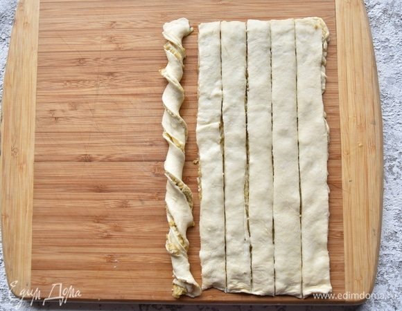 Сверху накрыть начинку оставшимся тестом. Слегка прижать и нарезать по длине полосками шириной 1,5–2 см. Каждую полоску аккуратно перекрутить, чтобы получилось подобие спирали.