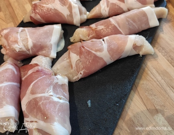 Куриное филе промыть, просушить и нарезать на кусочки средней величины. Посолить и поперчить, каждый обернуть в кусочек тонко нарезанной сыро-копченой ветчины.