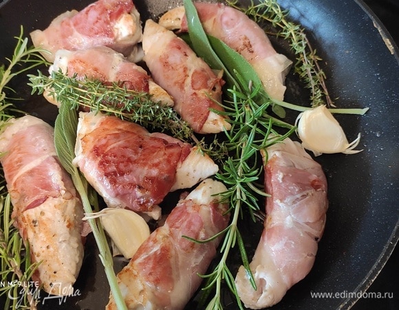 В сковороде разогреть масло и обжарить рулетики со всех сторон до золотистого цвета. Между рулетиками разложить веточки зелени и чеснок. Обжаренные рулетики и травы выложить на тарелку.