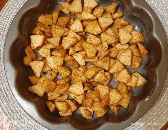 Яблоки почистить, убрать сердцевину и нарезать произвольно, добавить корицу и мускатный орех, хорошо перемешать и выложить на дно формы. Форму смазать сливочным маслом.