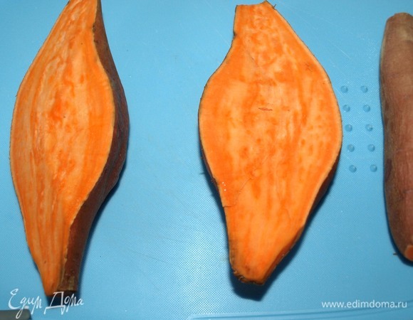 У меня большой клубень батата весом почти 500 г. Духовку разогреть до 190°C. Пока духовка разогревается, батат тщательно вымыть, высушить и разрезать на 2 части вдоль. Батат можно есть с кожурой, поэтому ее надо очистить и вымыть очень тщательно. Сделать несколько проколов, но так, чтоб не повредить кожуру.